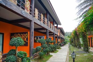 Un hôtel doté d’une galerie couverte, de nombreux balcons et d’arbres décoratifs.