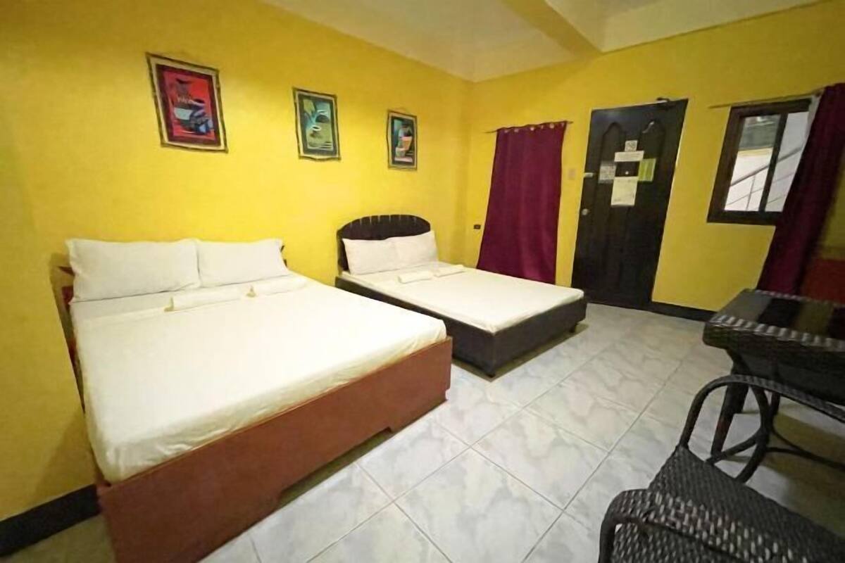 A room with two beds, a table, and chairs.