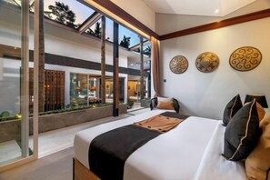 A modern hotel room with a large bed, a view of the outdoor area, and decorative wall art. - Villa Crazy Roof by BaliSuperHost (Bali)