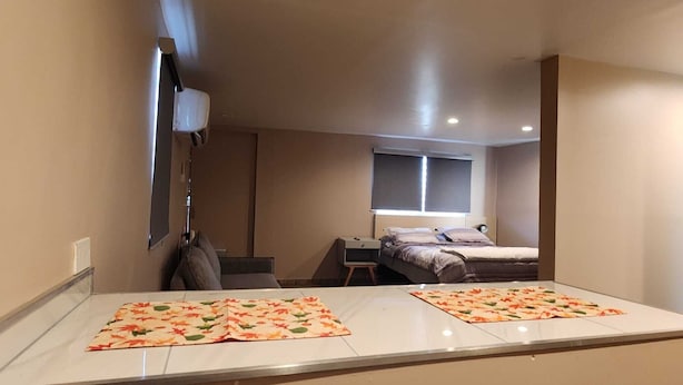 Ein kleiner, moderner Raum mit einem Bett, einem Schreibtisch und einem Stuhl.