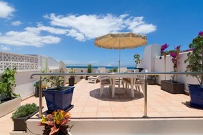 A rooftop terrace with outdoor furniture, potted plants, and a view of the sea. - Excelsior I Casa LEX Ocean&Sunrise Views Steps to Beach&Dunes Terrace Pool (Playa del Ingles)