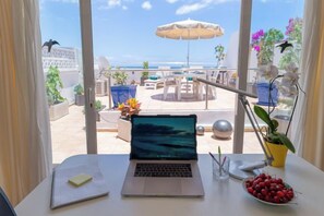 A laptop on a table with a view of a balcony, outdoor furniture, and a potted plant. - Excelsior I Casa LEX Ocean&Sunrise Views Steps to Beach&Dunes Terrace Pool (Playa del Ingles)