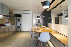 A compact kitchen with a dining area, built-in appliances, and pendant lighting. - RumahKu Georgetown (George Town)