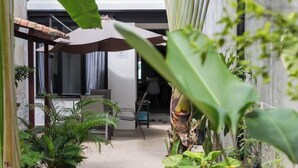 A covered outdoor area with potted plants and a wooden structure. - RumahKu Georgetown (George Town)