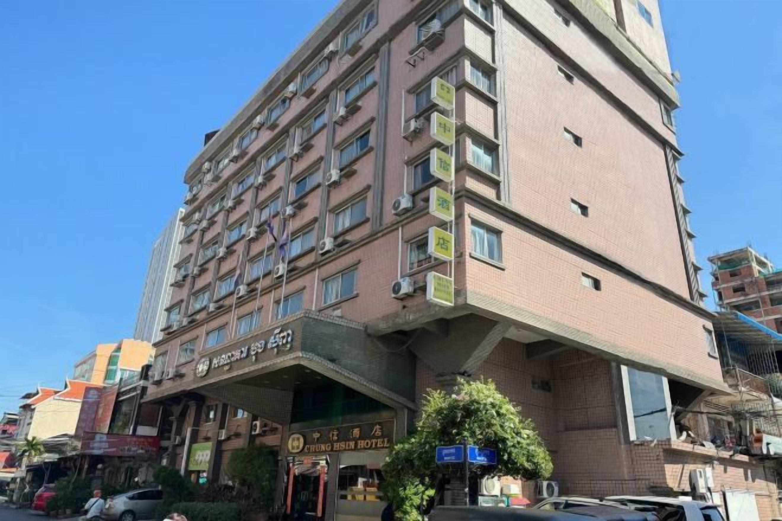 Un hotel de varios pisos con una entrada destacada y señalización.