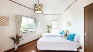 A bedroom with two beds, a potted plant, a globe, and a window with curtains. - Ocean Therapy House (Onna)