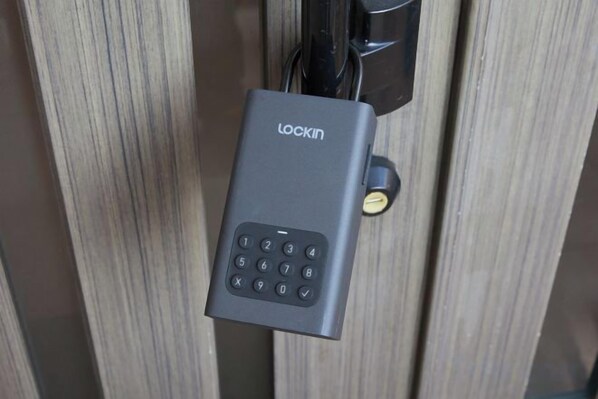 A door lock with a numeric keypad, a keyhole, and a key inserted. - Ocean Therapy House (Onna)