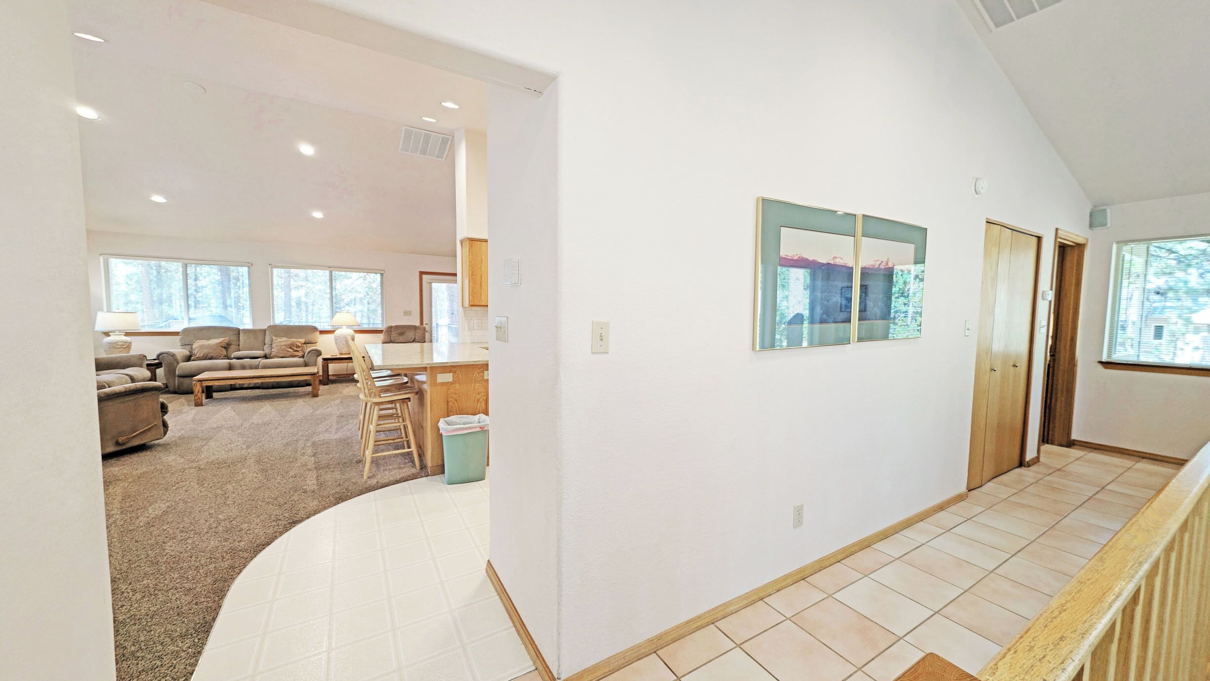 A spacious living area with a kitchen, a dining table, and a large window.
