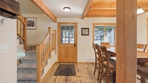 A wooden staircase leading to a dining area with a view of the outdoors.