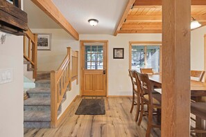 A wooden staircase leading to a dining area with a view of the outdoors. - Otter 8- SO Close to SHARC! Updated, Hot Tub, SHARC, A/C (Sunriver)
