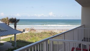 A balcony with a view of the beach, a palm tree, and a clear sky. - NEW! Beautiful Ocean View Studio in Daytona Beach (Daytona Beach)