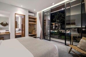 A bedroom with a bed, a wardrobe, a bench, and a sliding glass door leading to a balcony. - Villa Jehanne by BaliSuperHost (Bali)