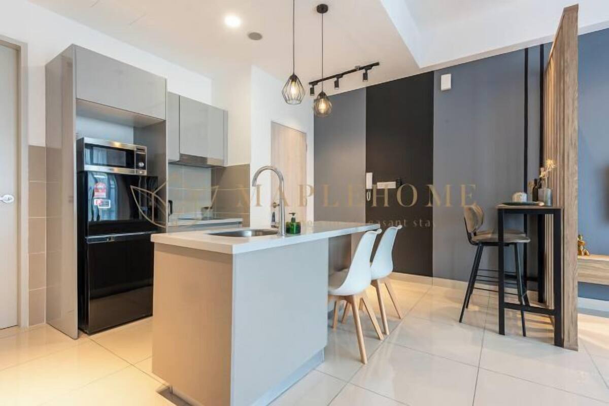 A modern kitchen with a central island, built-in appliances, and a dining area with bar stools.