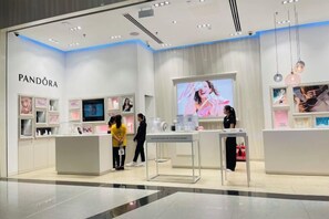 A clean, modern retail store with a prominent brand name on the wall, a central display area, and a checkout counter. - Landmark Cityview Apartment (Ho Chi Minh City)