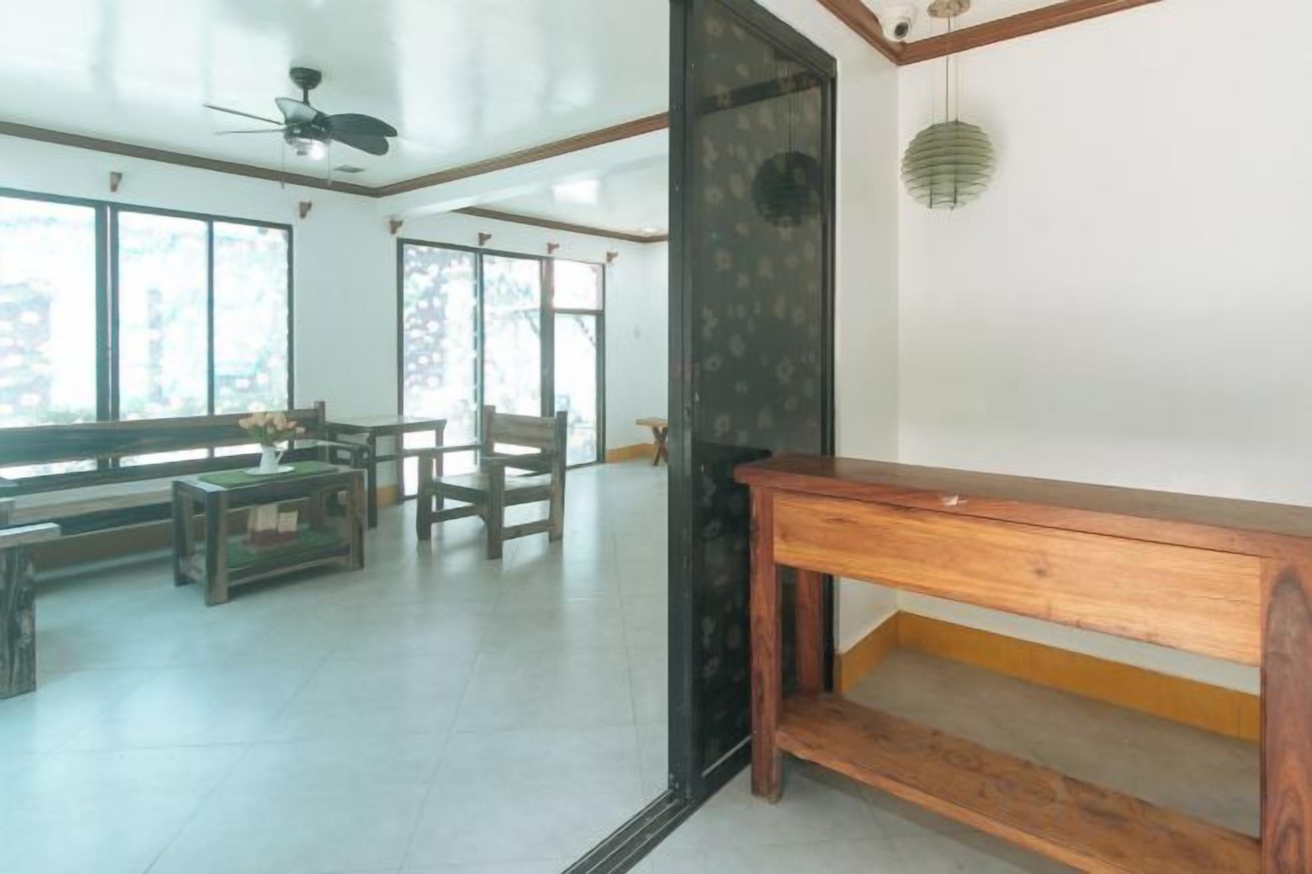 Un amplio espacio de sala con un banco de madera, una mesa y un sofá.