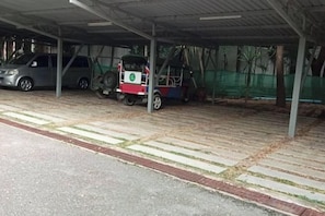 A covered parking area with a vehicle and a three-wheeled auto-rickshaw. - Keankan Resort (Kanchanaburi)