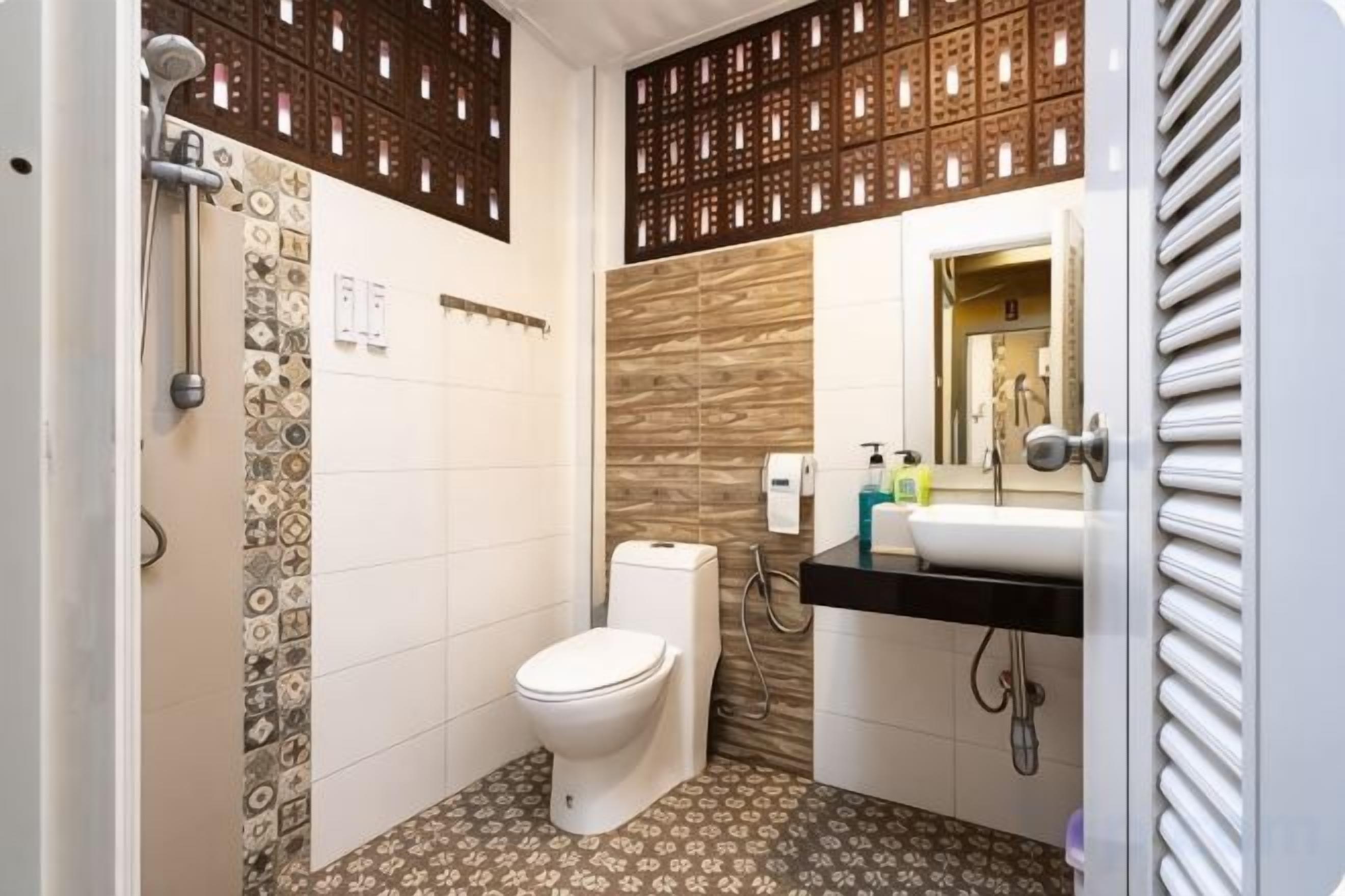 A bathroom with a toilet, shower, and sink.