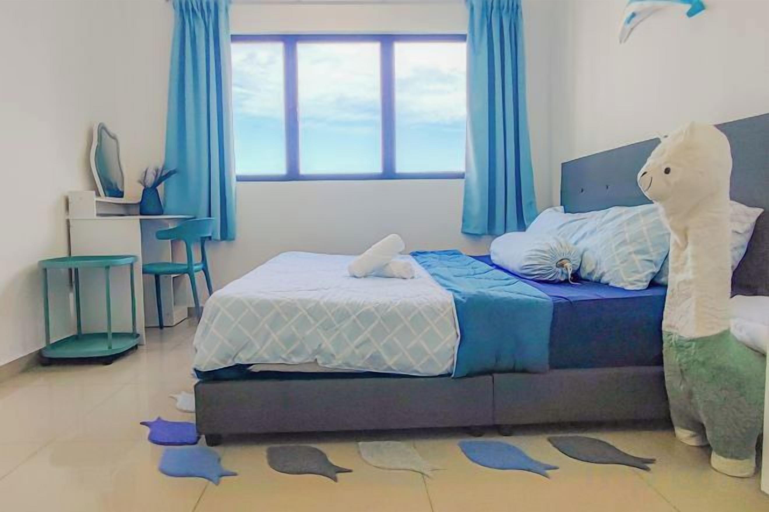 A bedroom with a bed, a desk, a chair, and a window with curtains.