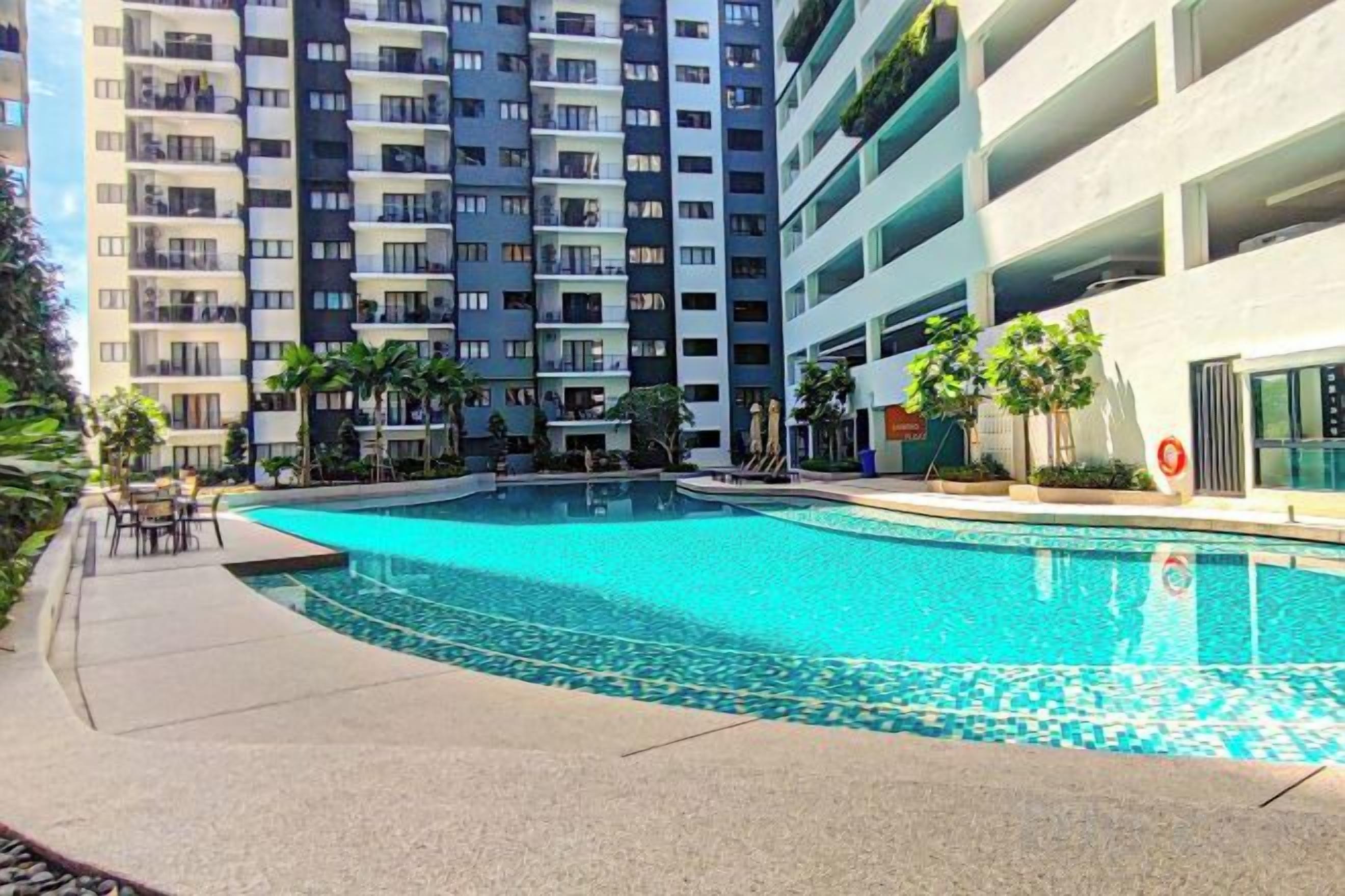 A swimming pool surrounded by a multi-story residential building with balconies.