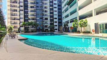 A swimming pool surrounded by a multi-story residential building with balconies.