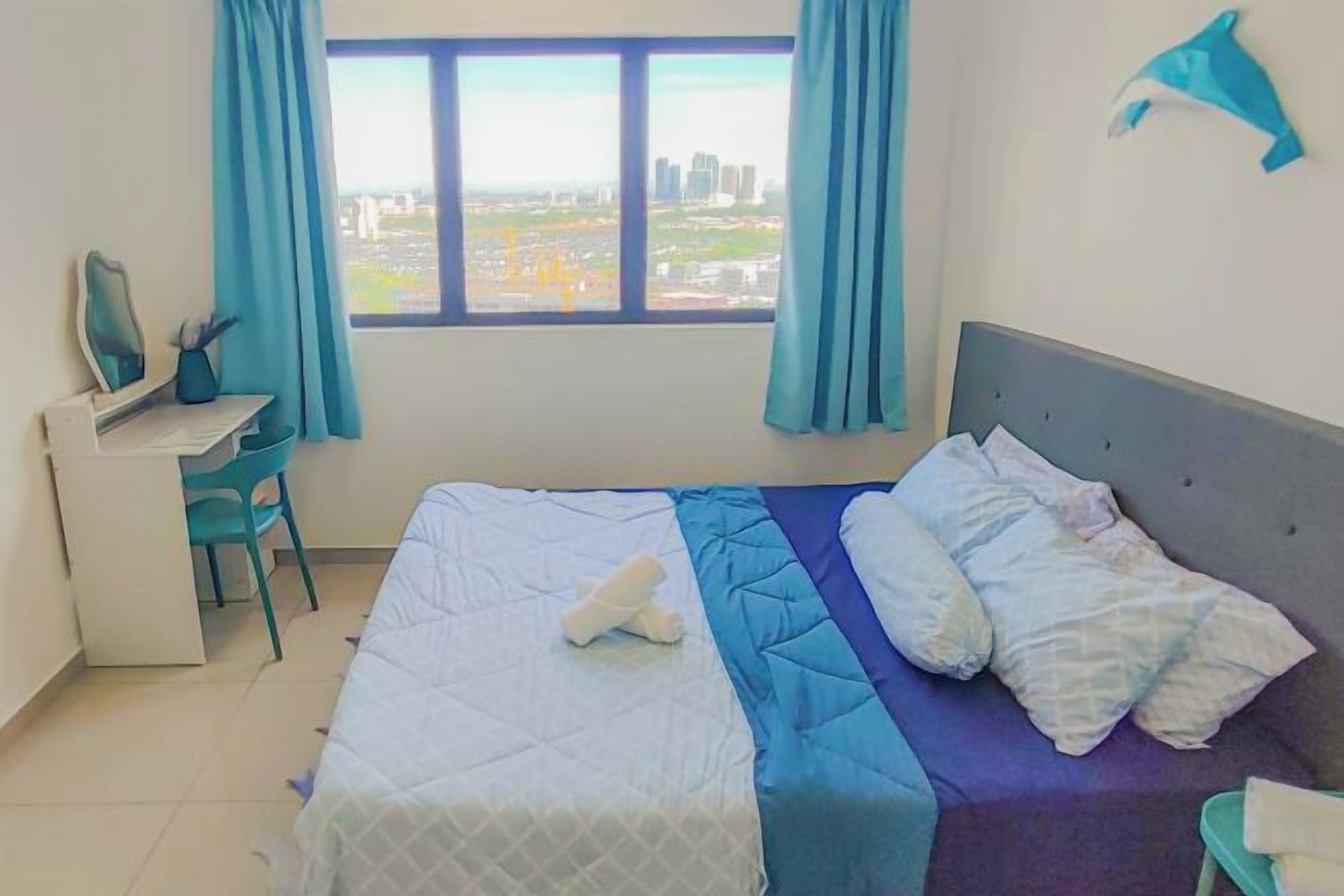 Hotellihuone, jossa on sänky, työpöytä ja näkymä kaupunkiin.