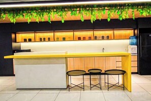 A modern kitchen with a bar area, bar stools, and a water dispenser. - Fluffy Stay at Huni Setia Alam by HCK (Shah Alam)