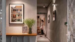 A hallway with a reception desk, framed artwork, and a potted plant. - Express by M Village Pham Ngu Lao, a brand of Modern Village Lifestyle (Ho Chi Minh City)