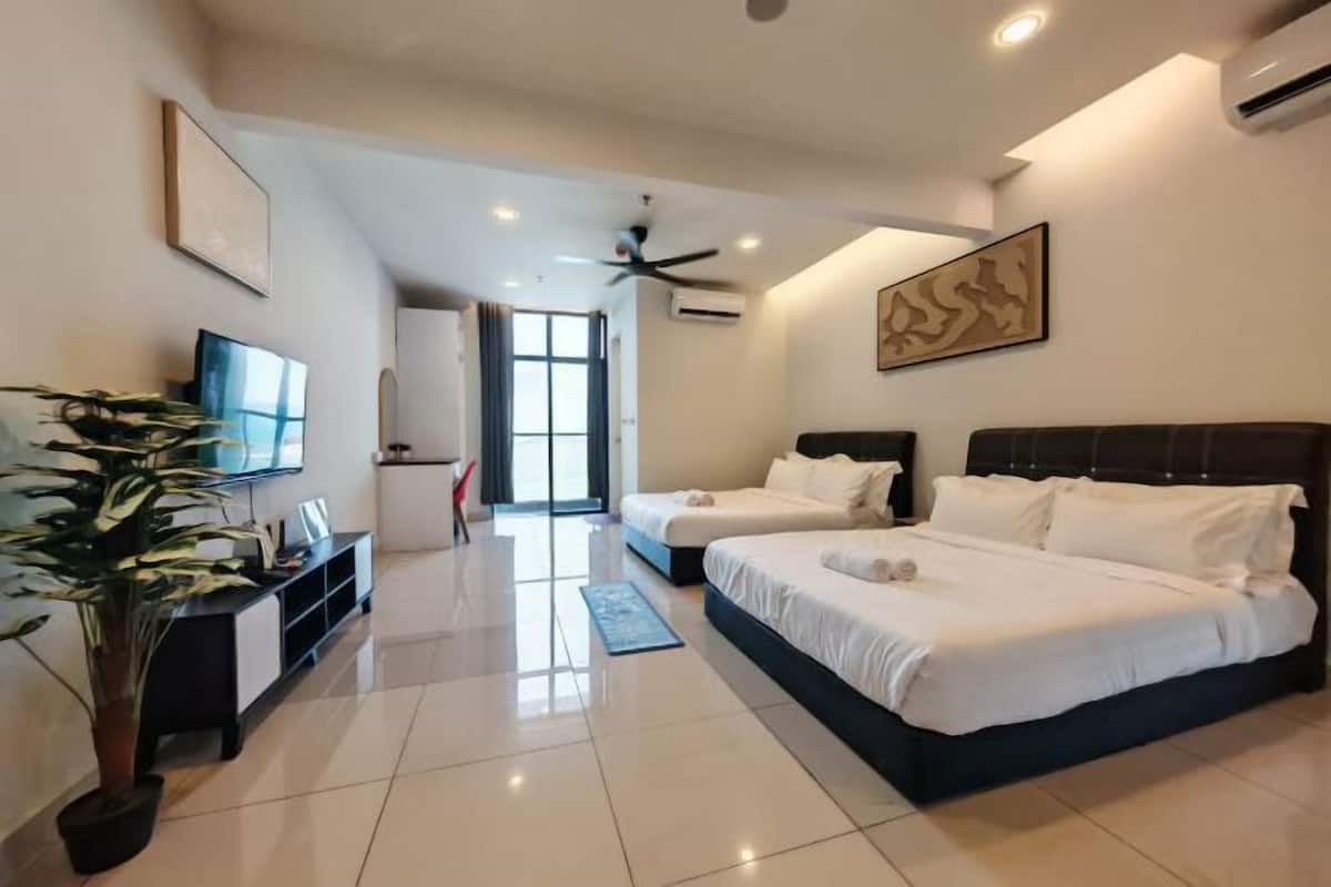 A modern hotel room with two beds, a TV, a plant, and a large window.