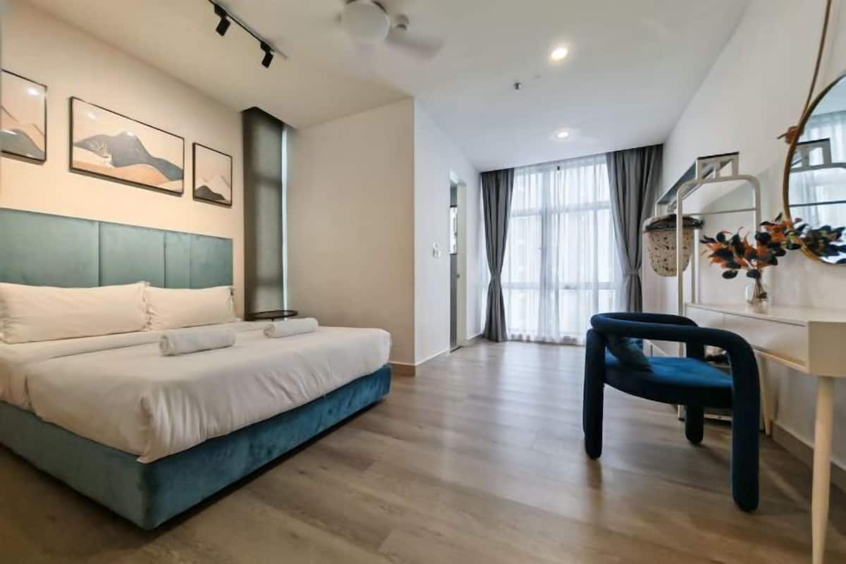 A modern bedroom with a bed, a chair, and a desk.