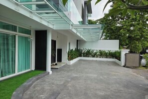 A modern house with a glass conservatory, a concrete driveway, and a well-maintained lawn. - Villa Homescape, Mont Kiara (Kuala Lumpur)