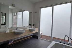 A modern bathroom with a large mirror, two sinks, and a bathtub. - Villa Homescape, Mont Kiara (Kuala Lumpur)