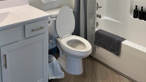 A modern bathroom with a toilet, sink, and shower area.