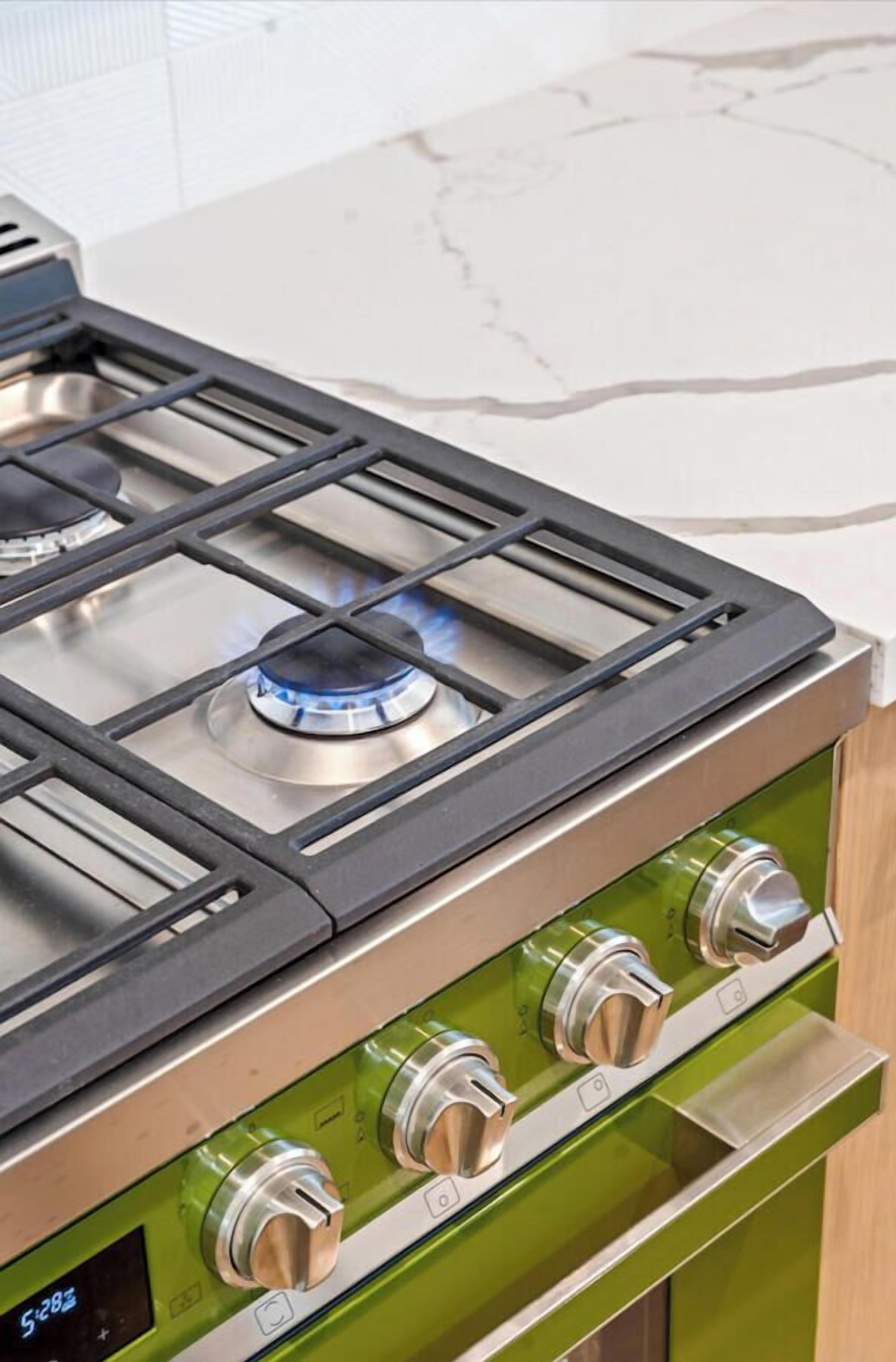 Cocina equipada con estufa a gas, cuatro hornillas y pantalla digital.