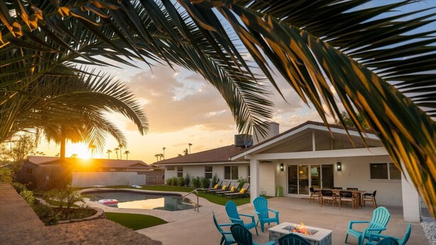 Un resort con piscina, zona de estar al aire libre y vistas al atardecer.
