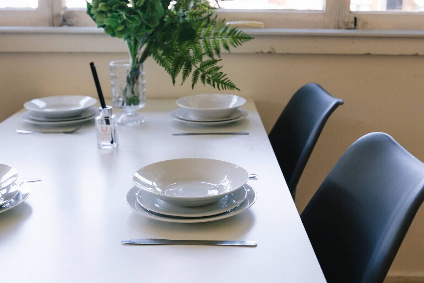 Mesa de jantar posta com pratos, um copo e um garfo.