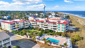 Hotel frente al mar con varios balcones, piscina y vistas al océano.