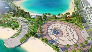 An aerial view of a coastal area with a circular park, a beach, and a modern structure with a dome-like roof. - It Dust Homestay 6 - the Forest Apartment (Hanoi)