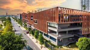 A modern building with a prominent emblem, multiple floors, and a surrounding urban environment. - It Dust Homestay 6 - the Forest Apartment (Hanoi)
