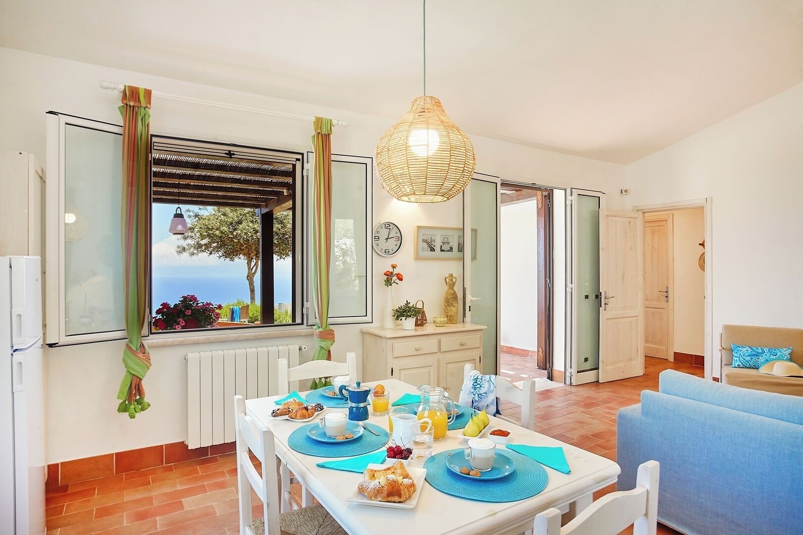 Een eetruimte met een ontbijttafel, uitzicht op zee door een raam, en een modern interieur.