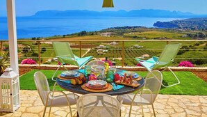 A table set for a meal with a scenic view of a lake and mountains in the background. - Brezza del Vento, Scopello area, Sicily (Scopello)