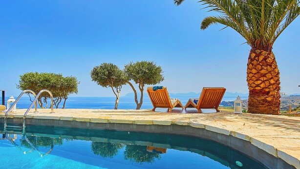 A pool with clear blue water, wooden lounge chairs, and a palm tree. - Brezza del Vento, Scopello area, Sicily (Scopello)