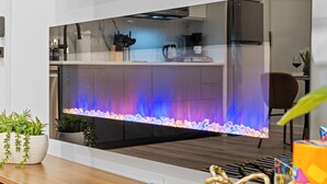 Een moderne keuken met een groot aquarium, een houten aanrecht en diverse keukenapparaten.