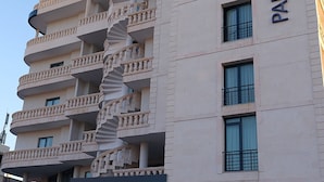 A multi-story building with a spiral staircase and balconies. The building has a sign that reads "PARK DEDEMAN". - Park Dedeman Midyat (Midyat)
