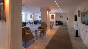 A spacious living area with multiple seating options, a fireplace, and artwork on the walls. - Park Dedeman Midyat (Midyat)