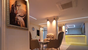 A modern interior with a dining area featuring a table and chairs, a framed artwork on the wall, and a bright, well-lit space with a radiator and air conditioning unit. - Park Dedeman Midyat (Midyat)
