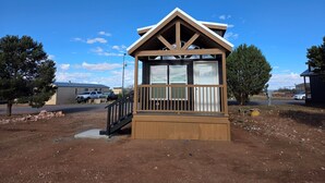 A small wooden cabin with a balcony, a staircase, and a view of the surrounding area. - Star Gazing Chalet: Closest to South Rim (20 Min),King Bed/Loft (Williams)