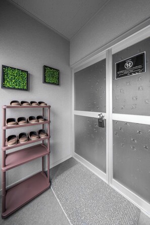 A hallway with a shoe rack, frosted glass doors, and framed artwork on the wall. - WHITEGARDEN YIG STAY (Furano)