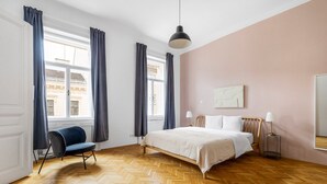 Une chambre d’hôtel avec un grand lit, une chaise, un bureau et une fenêtre avec des rideaux.