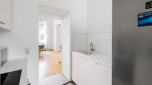 Une cuisine moderne dotée d’un évier encastré, d’un réfrigérateur en acier inoxydable et donnant sur la salle à manger.