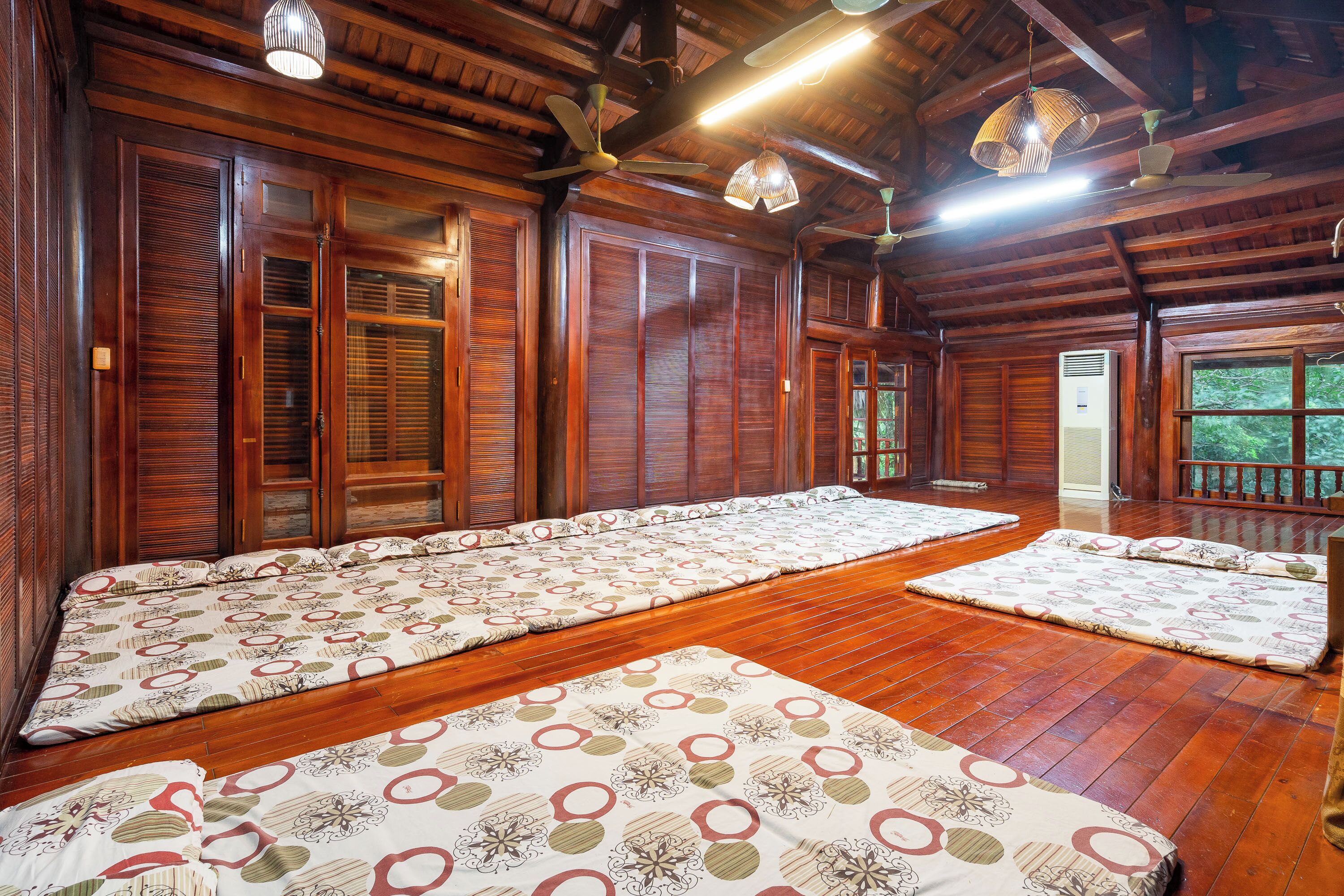 Une pièce traditionnelle en bois, dotée de tatamis, de portes coulissantes en bois et d’un ventilateur de plafond.